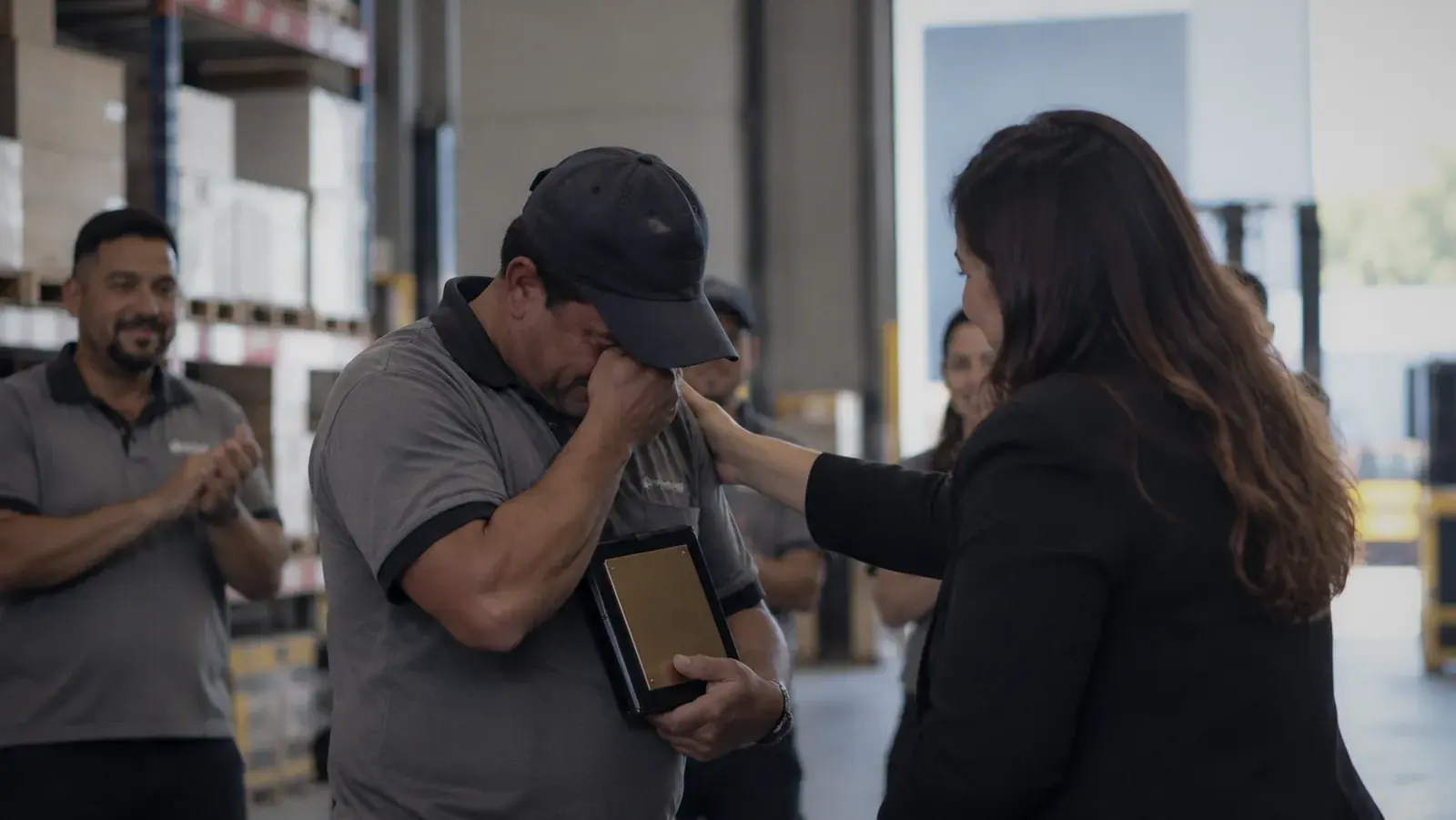 Colaborador emocionado ao receber a placa de reconhecimento